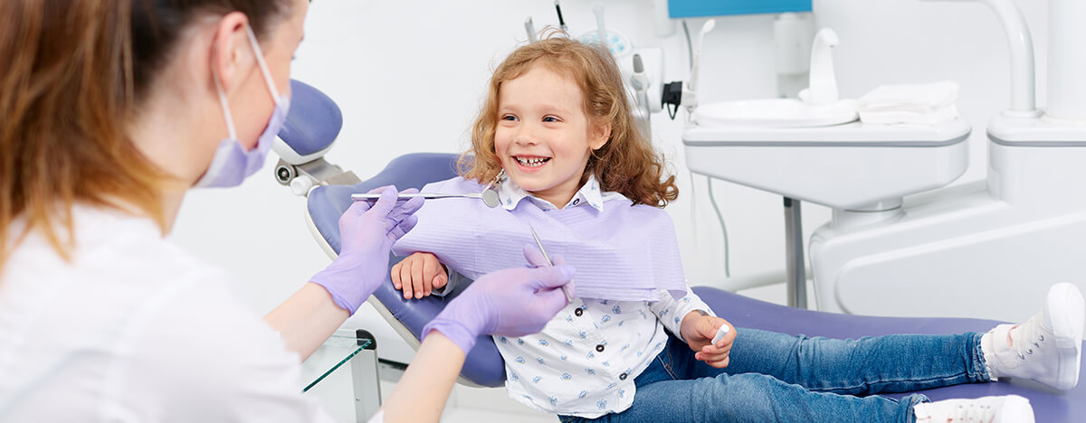female dentist with a girl smiling