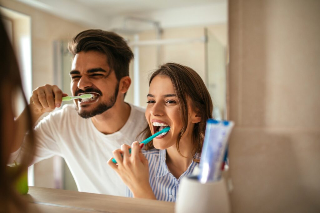 couple brushing teeth together at home