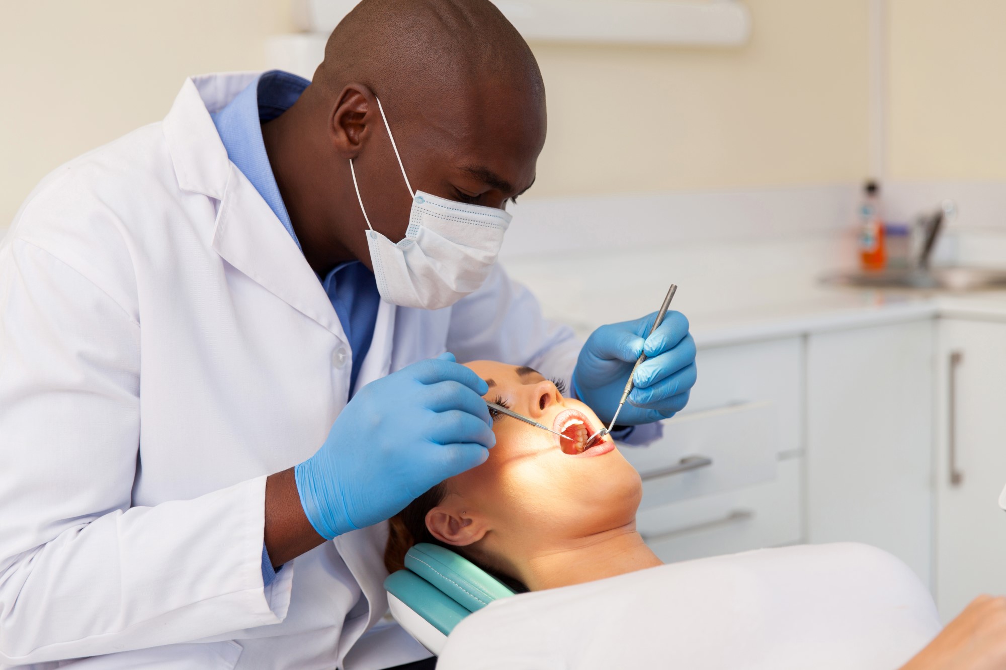 Dentist visit underway with dentist inspecting patient's teeth