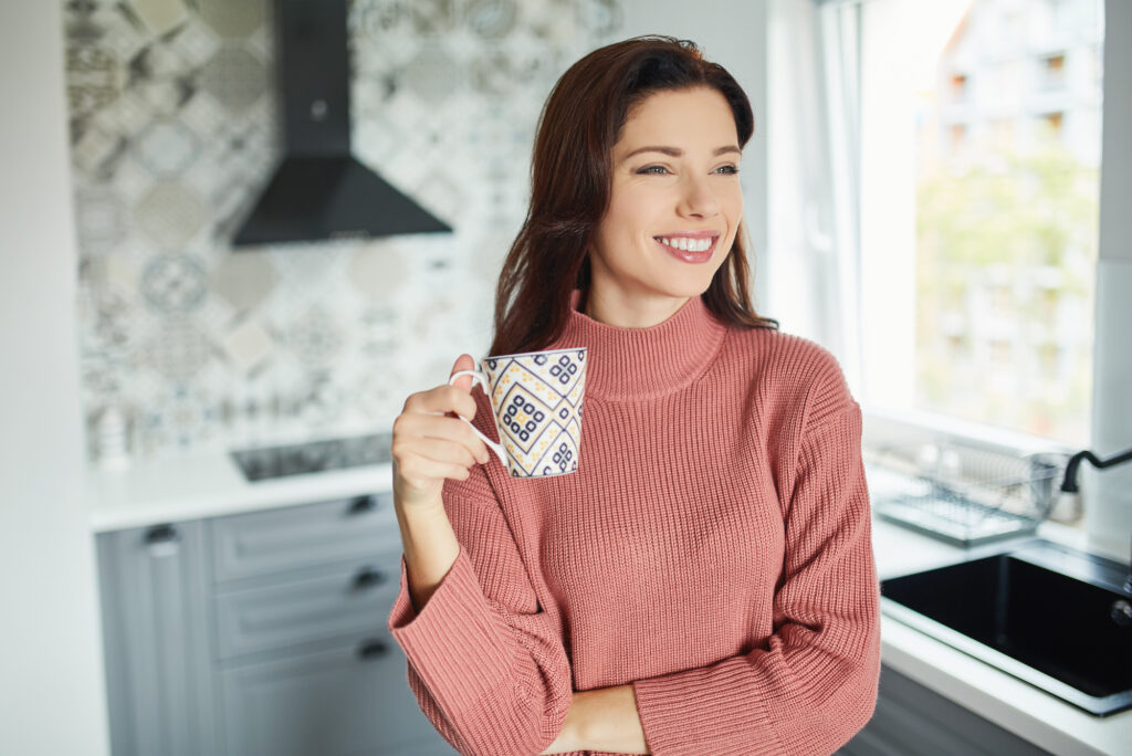 Woman with morning coffee in the kitchen