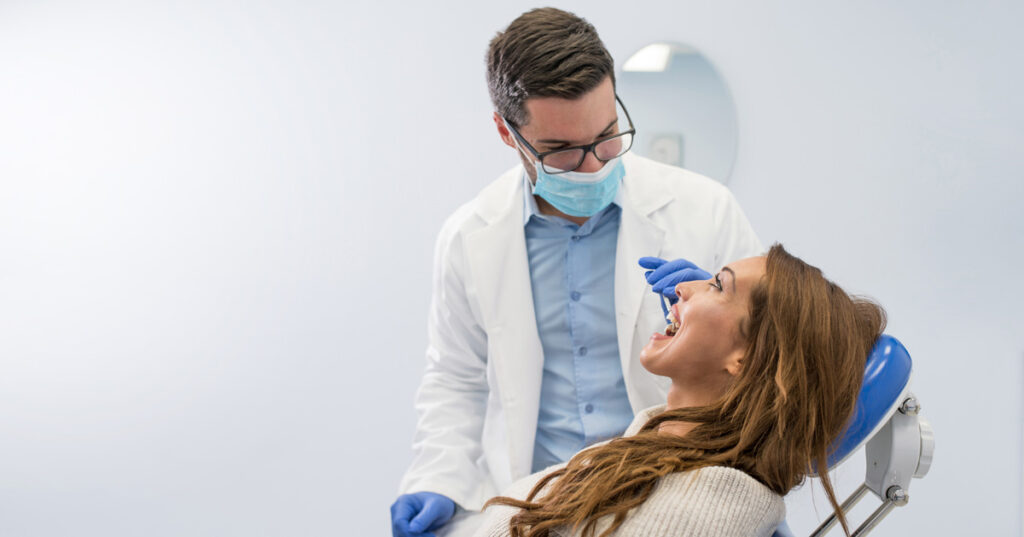 An East El Paso dentist examining a woman’s mouth.