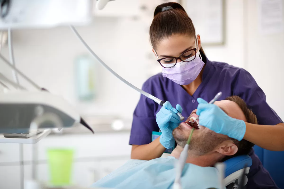 A dentist pulling a man’s tooth at a family dentist's office in El Paso.